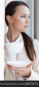 Thoughtful businesswoman having coffee in office