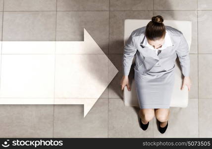 Thoughtful businesswoman. Top view of thoughtful businesswoman sitting on chair