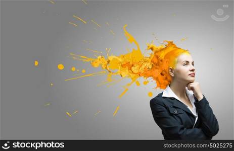 Thoughtful businesswoman with colorful splashes out of her head. Woman with colored head