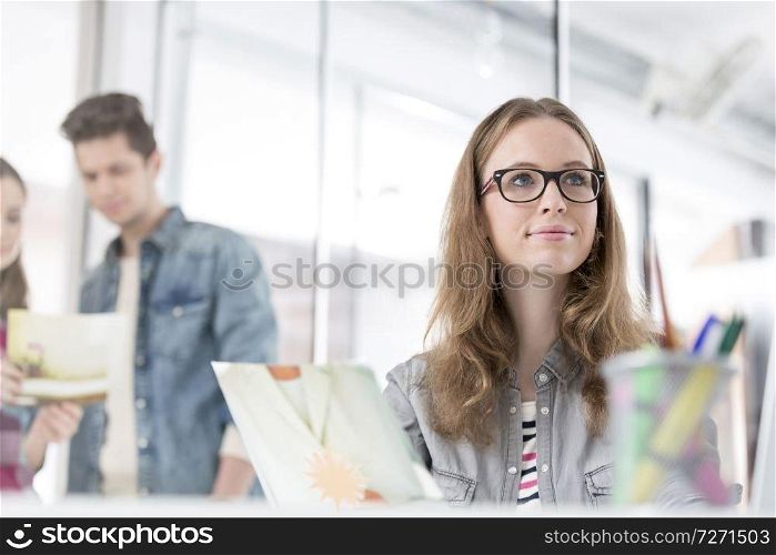 Thoughtful businesswoman with photograph sitting in office