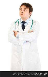 Thoughtful doctor with crossed arms on chest looking up at copy space isolated on white&#xA;