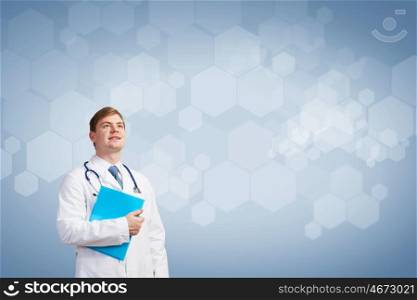 Thoughtful doctor. Young man doctor holding folder thinking something over