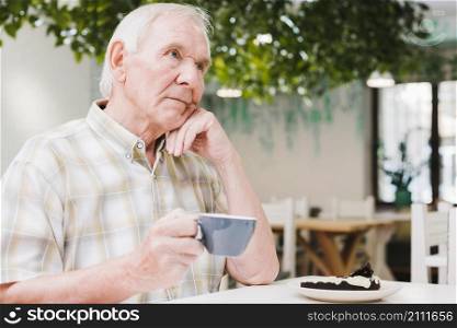 thoughtful elderly man drinking tea