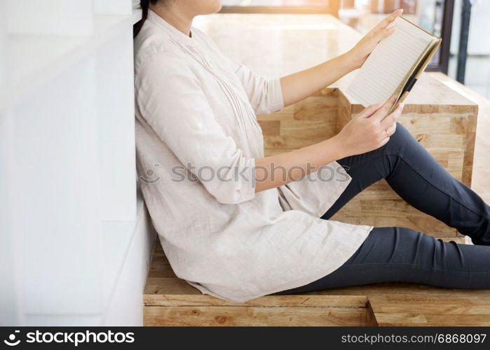 Thoughtful female student sitting Serious reading a book in a library floor, Education concept