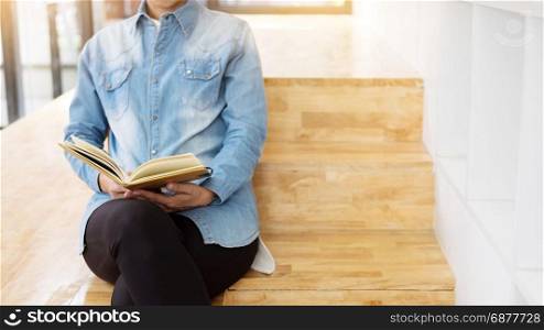 Thoughtful female student sitting Serious reading a book in a library floor, Education concept