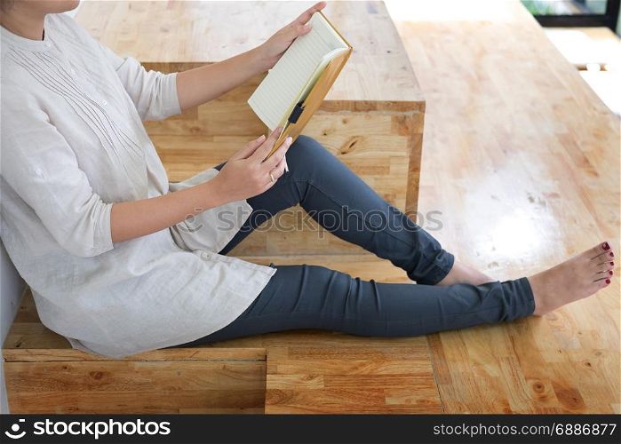 Thoughtful female student sitting Serious reading a book in a library floor, Education concept