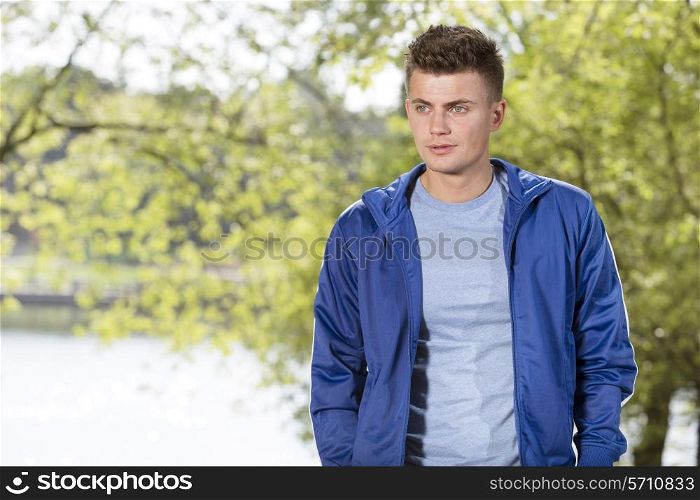 Thoughtful fit young man standing in park