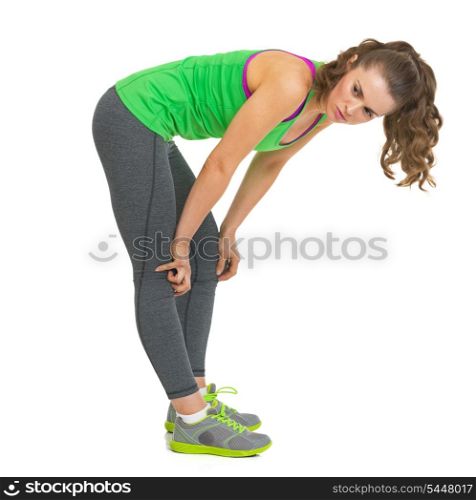 Thoughtful fitness young woman bent down