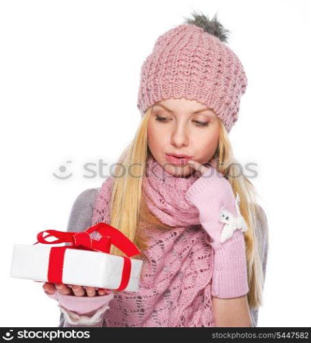 Thoughtful girl in winter clothes looking on christmas present box