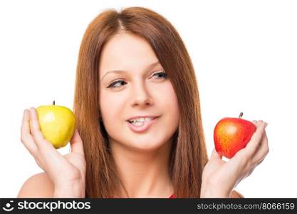 thoughtful girl makes a choice between apples on a white background isolated