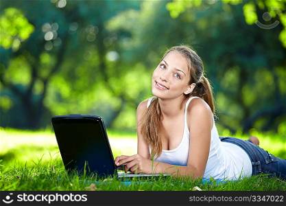 Thoughtful girl with a laptop in the park