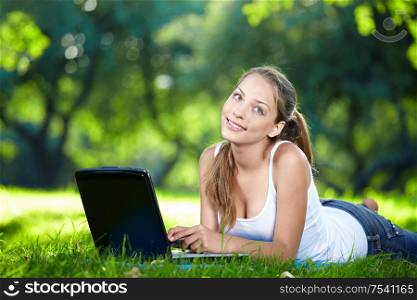 Thoughtful girl with a laptop in the park