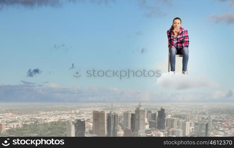 Thoughtful girl. Young thoughtful woman in casual sitting in chair