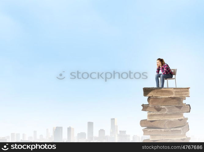 Thoughtful girl. Young thoughtful woman in casual sitting in chair