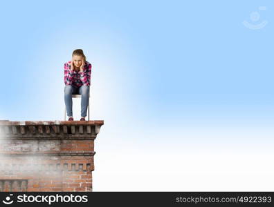 Thoughtful girl. Young thoughtful woman in casual sitting in chair