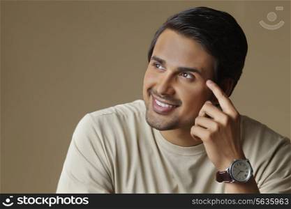 Thoughtful Indian man looking at copy space over colored background