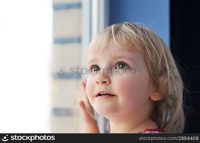 thoughtful little girl is by window portrait