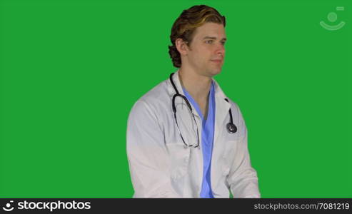 Thoughtful looking doctor turns to camera (Green Key)