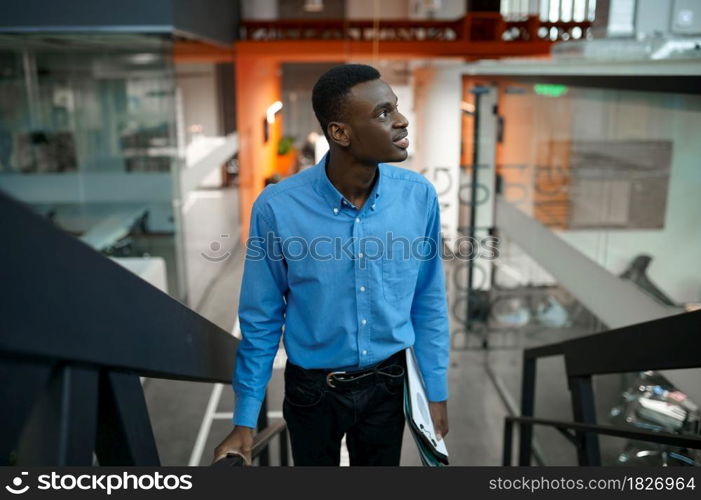 Thoughtful male manager on stairs, idea developing in IT office. Professional worker, planning or brainstorming. Successful businessman works in modern company. Thoughtful manager, idea developing in IT office