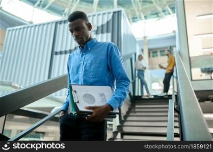 Thoughtful male manager on stairs, idea developing in IT office. Professional worker, planning or brainstorming. Successful businessman works in modern company. Thoughtful manager, idea developing in IT office