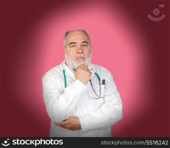 Thoughtful old doctor on a over pink background