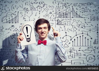 Thoughtful student with notebook. Image of thoughtful male student holding notebook in classroom