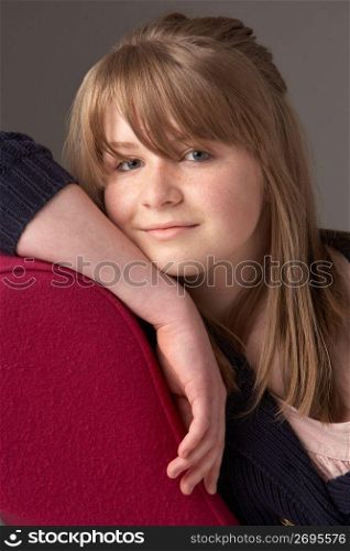 Thoughtful Teenage Girl Relaxing On Chaise Longue