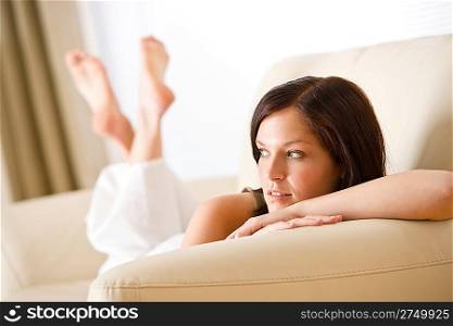 Thoughtful woman relax in lounge on beige sofa
