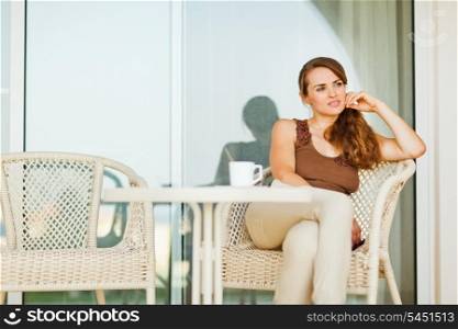 Thoughtful woman sitting on terrace