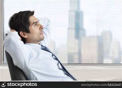 Thoughtful young business man relaxing on office chair