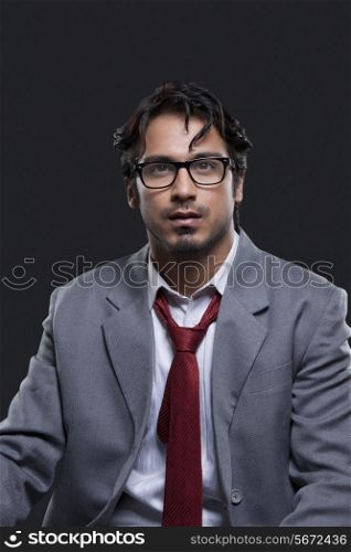 Thoughtful young businessman against black background