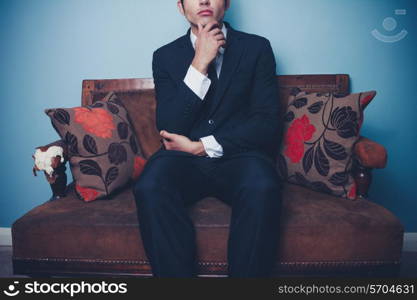 Thoughtful young businessman on sofa