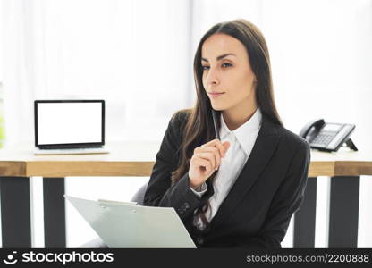 thoughtful young businesswoman with pen clipboard her hand