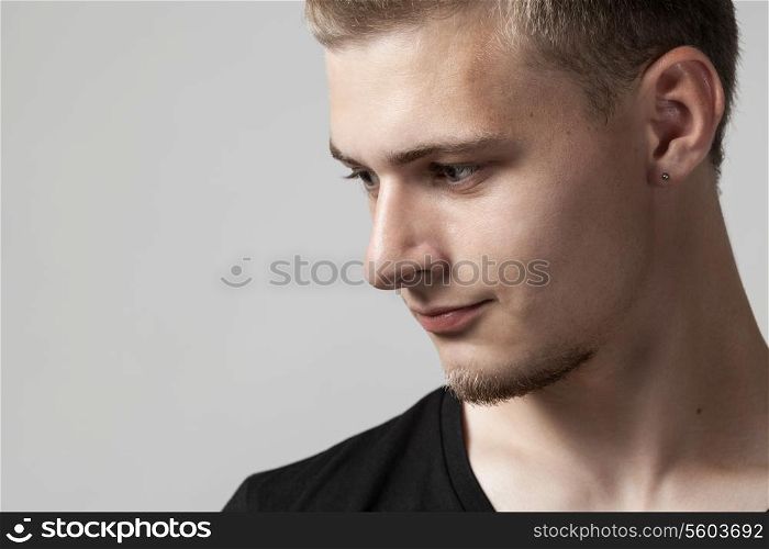 thoughtful young caucasian man isolated on gray background