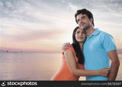 Thoughtful young couple embracing at beach