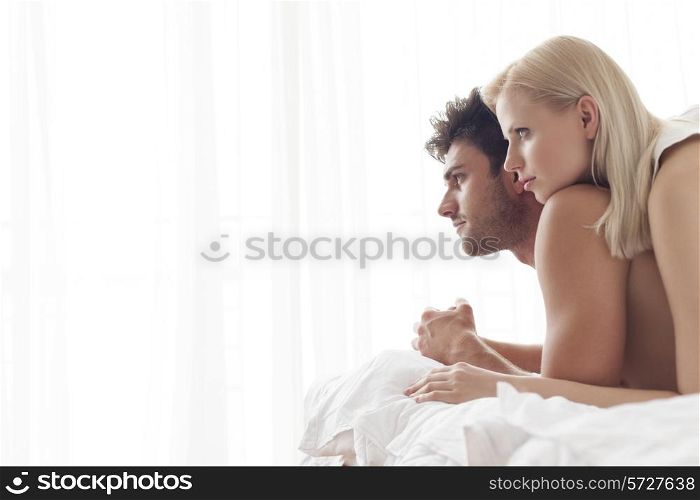 Thoughtful young couple in bed