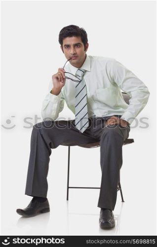 Thoughtful young executive sitting on chair