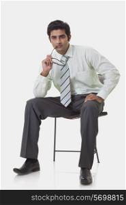 Thoughtful young executive sitting on chair