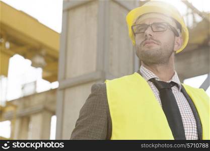 Thoughtful young male architect in protective wear at construction site
