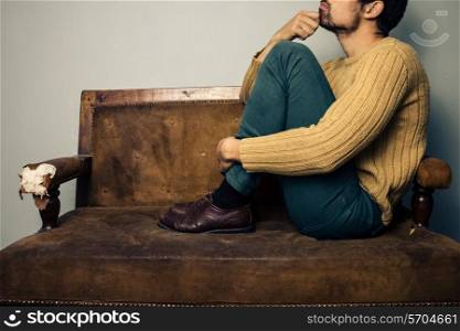 Thoughtful young man sitting on a sofa
