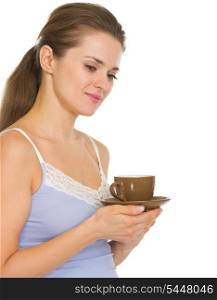 Thoughtful young woman in pajamas after sleep with cup of coffee