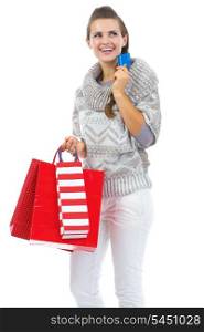 Thoughtful young woman in sweater with christmas shopping bag and credit card