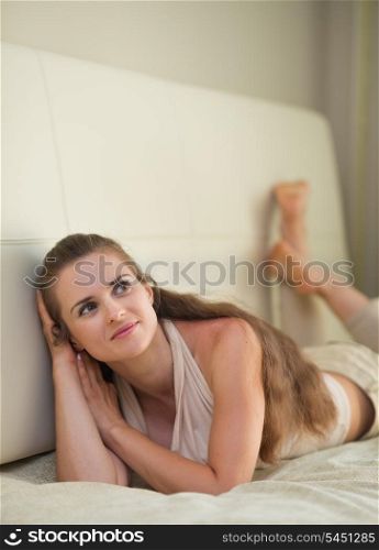 Thoughtful young woman laying on sofa