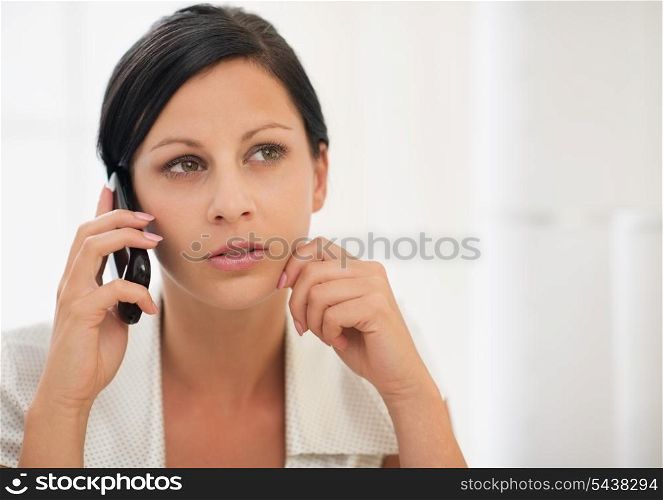 Thoughtful young woman speaking mobile phone