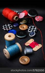 thread and buttons for sewing master on black background.Selective focus. working tool dressmaker