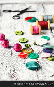 Thread,buttons,beads and scissors on the table light vintage