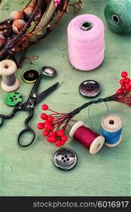 Thread for sewing,buttons and decoration on wooden background.