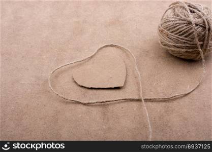 Thread off spool form a heart shape on brown background
