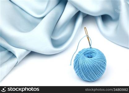 thread on blue silk isolated close up