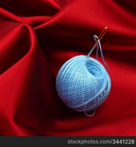 thread on red silk isolated close up